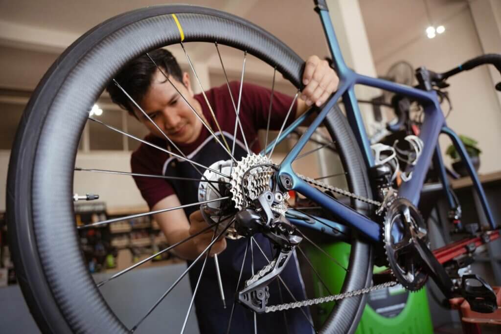 Esperto in un'officina di riparazione di biciclette a Montpellier che esamina un sistema di catene danneggiato.