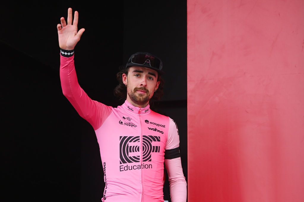 Ben Healy waves to the crowd as he walks on the Amstel Gold Race podium to collect his runner-up prize